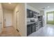 Well-lit kitchen featuring dark cabinetry, stainless steel appliances, and tiled flooring at 10705 E Sunflower Ct, Florence, AZ 85132