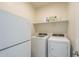 The laundry room features a washer, dryer, shelving and a spare refrigerator at 10705 E Sunflower Ct, Florence, AZ 85132