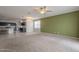 Open living space featuring carpet, green accent wall, and view of kitchen and dining area at 10705 E Sunflower Ct, Florence, AZ 85132