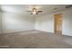 Large main bedroom with neutral carpet, lots of natural light, and an ensuite bathroom entrance at 10705 E Sunflower Ct, Florence, AZ 85132