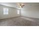 Bright main bedroom featuring plush carpet, neutral paint, and ample natural light from large windows at 10705 E Sunflower Ct, Florence, AZ 85132