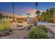 Desert landscaped backyard featuring a pool, patio, and mature trees at 11041 N 44Th St, Phoenix, AZ 85028