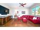 Inviting living room with TV, cactus view from the window, and a large red couch at 11041 N 44Th St, Phoenix, AZ 85028