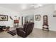 Open living room with tiled floor, ceiling fan, and comfortable leather seating at 11139 W Cameo Dr, Sun City, AZ 85351