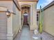 Inviting front entrance with a wooden door, decorative lighting, and desert landscaping at 11256 S Hopi Dr, Goodyear, AZ 85338