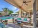 Inviting covered patio with a wicker sofa, ceiling fan and a pool and pergola beyond at 11256 S Hopi Dr, Goodyear, AZ 85338