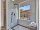 Modern walk-in shower with gray and white tile, rain shower head, and backyard window at 11256 S Hopi Dr, Goodyear, AZ 85338