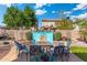 Inviting backyard featuring a fire pit with stylish seating and a decorative turquoise water feature at 12038 W Briles Rd, Peoria, AZ 85383