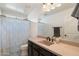 Bathroom featuring a mirror, shower with curtain, sink, cabinet, and toilet at 12038 W Briles Rd, Peoria, AZ 85383