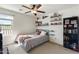 Bedroom featuring neutral walls, carpet, ceiling fan, and sports themed decor at 12038 W Briles Rd, Peoria, AZ 85383