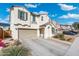 A two-story home with a driveway and manicured landscaping under a bright blue sky at 12038 W Briles Rd, Peoria, AZ 85383