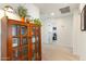 Hallway showcasing carpet, open doorways, and built in bookcase with glass doors and display lighting at 12038 W Briles Rd, Peoria, AZ 85383