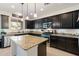 Modern kitchen featuring dark cabinets, granite countertops, stainless steel appliances, and an island at 12038 W Briles Rd, Peoria, AZ 85383