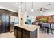 Bright open kitchen with a granite island, stainless steel refrigerator, and modern pendant lights at 12038 W Briles Rd, Peoria, AZ 85383