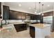 Modern kitchen featuring dark cabinets, granite countertops, stainless steel appliances, and a breakfast bar at 12038 W Briles Rd, Peoria, AZ 85383