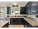 Stylish kitchen with dark cabinetry, granite countertops, stainless steel dishwasher, and backyard view at 12038 W Briles Rd, Peoria, AZ 85383