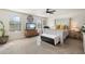 Bright main bedroom featuring a decorative ceiling fan, dresser, and bench by the distressed bed frame at 12038 W Briles Rd, Peoria, AZ 85383