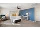 Spacious main bedroom featuring a blue accent wall, chair, and distressed bed frame with bench at 12038 W Briles Rd, Peoria, AZ 85383