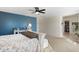 Open main bedroom with blue accent wall, bedside table, and doorway leading to walk-in closet at 12038 W Briles Rd, Peoria, AZ 85383