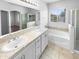 Primary bathroom featuring a soaking tub, double sinks, and a separate glass shower enclosure at 12163 W Chase Ln, Avondale, AZ 85323