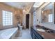 Bright bathroom features a soaking tub, glass block window, and walk-in shower at 1219 E Seminole Dr, Phoenix, AZ 85022