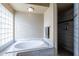 Soaking tub with tile surround and shower with marble tile at 1219 E Seminole Dr, Phoenix, AZ 85022