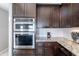 Close-up of the kitchen, featuring stainless steel appliances, granite counters and warm wood cabinetry at 1219 E Seminole Dr, Phoenix, AZ 85022