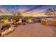 Beautiful backyard with a fire pit and a built-in barbeque, set against a colorful sunset at 13719 W Creosote Dr, Peoria, AZ 85383