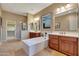 This primary bathroom features dual vanities, a soaking tub, and a glass-enclosed walk-in shower at 13719 W Creosote Dr, Peoria, AZ 85383