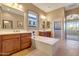 An expansive bathroom features dual vanities, a soaking tub, and natural light from the large picture window at 13719 W Creosote Dr, Peoria, AZ 85383