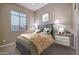 This well-lit bedroom boasts a plush bed, stylish decor, and comfortable carpet at 13719 W Creosote Dr, Peoria, AZ 85383