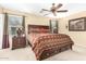 Comfortable bedroom featuring a ceiling fan, carpet, and large window at 1458 N 80Th Ln, Phoenix, AZ 85043