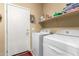 Well-lit laundry room with a washer and dryer, plus shelving for storage at 1458 N 80Th Ln, Phoenix, AZ 85043