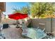 Private outdoor patio with a table and chairs, shaded by a large umbrella at 1458 N 80Th Ln, Phoenix, AZ 85043