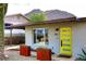 Close-up of a modern single-story home featuring desert landscaping, metal planters and a bright yellow front door at 1515 E Sunnyslope Ln, Phoenix, AZ 85020