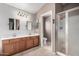 Well-lit bathroom with dual sink vanity, modern lighting, and a walk-in shower at 16036 N 11Th Ave # 1126, Phoenix, AZ 85023