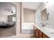 Well-lit bathroom featuring a dual sink vanity and separate tub overlooking the main bedroom at 16036 N 11Th Ave # 1126, Phoenix, AZ 85023