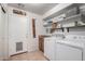 Well-organized laundry room with washer, dryer, sink, ample shelving, and stylish decorative accents at 16036 N 11Th Ave # 1126, Phoenix, AZ 85023