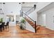 Open-concept living space with wood floors, modern staircase, and seamless flow to dining area at 16618 S 28Th Pl, Phoenix, AZ 85048