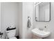 Efficient powder room with pedestal sink, modern mirror, and towel ring near the toilet at 16618 S 28Th Pl, Phoenix, AZ 85048