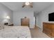 Comfortable bedroom with soft lighting, ceiling fan, and wooden dresser at 1706 E Lindrick Dr, Chandler, AZ 85249