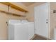 Convenient laundry room with a washer, dryer, and shelving for organization at 1706 E Lindrick Dr, Chandler, AZ 85249