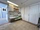 View of the versatile utility room with tile flooring, double-door closet, and built-in storage cabinets at 17200 W Bell Rd # 958, Surprise, AZ 85374