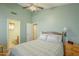 Cozy bedroom featuring light green walls, ceiling fan, and adjacent bathroom access at 1793 E Desert Inn Dr, Chandler, AZ 85249