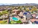 Drone shot of the home and backyard, highlighting the pool, putting green, and outdoor seating area at 18225 W Mackenzie Dr, Goodyear, AZ 85395