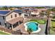 Aerial shot of the backyard, displaying a custom pool, putting green, patio, and desert landscaping at 18225 W Mackenzie Dr, Goodyear, AZ 85395