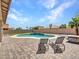 Relaxing backyard with a sparkling pool, patio with lounge chairs, and a built in BBQ area at 18225 W Mackenzie Dr, Goodyear, AZ 85395