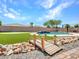 Backyard with a bridge leading to a pool, waterfall, and putting green at 18225 W Mackenzie Dr, Goodyear, AZ 85395