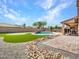 Beautiful backyard featuring a swimming pool, putting green, and ample patio space at 18225 W Mackenzie Dr, Goodyear, AZ 85395