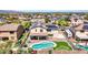 A bird's-eye view showcasing the backyard's pool, mini-golf, desert landscape, and neighborhood at 18225 W Mackenzie Dr, Goodyear, AZ 85395